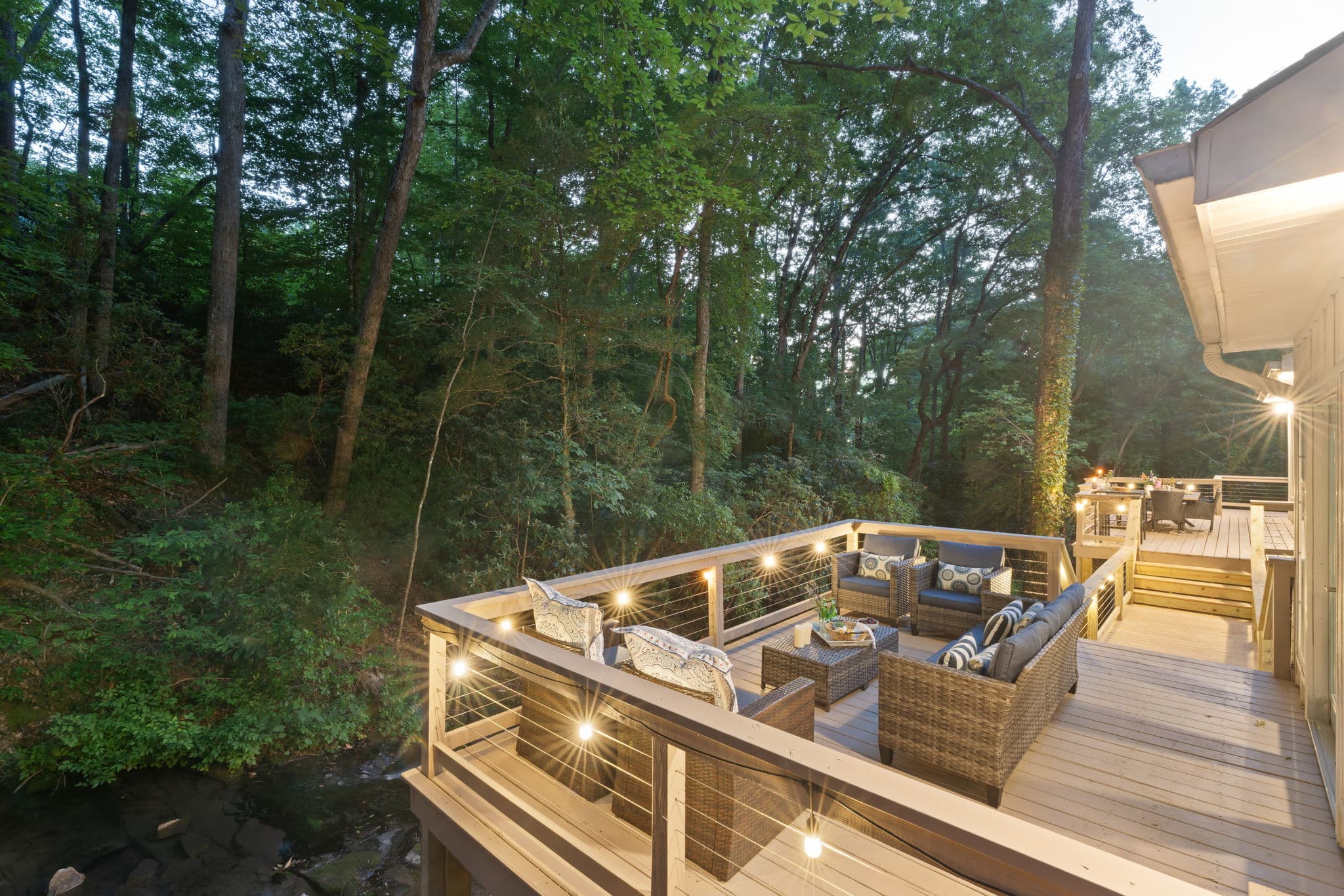 Illuminated creek deck at dusk — Falling Water North Georgia rental